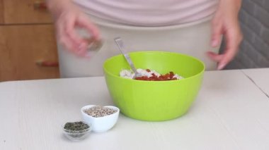 Yeşil karabuğdaydan ekmek yapmak. Bir kadın yeşil karabuğday hamuruna keten, ayçiçeği ve kabak çekirdeği ekler..