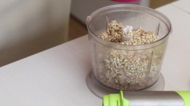 Yeşil karabuğdaydan ekmek yapmak. Bir kadın öğütücüye karabuğday koyar ve onu kapatır. Yakın çekim..