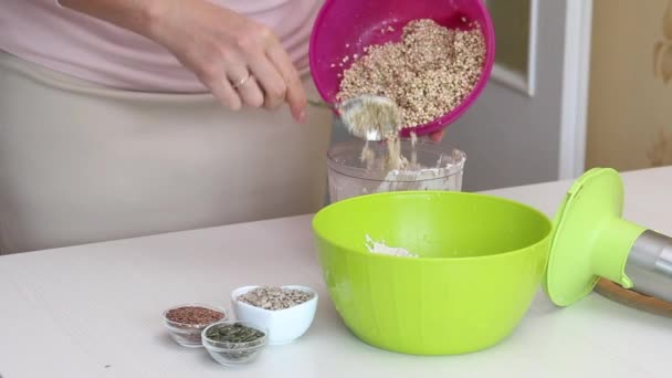 用绿色荞麦做面包 一个女人把绿荞麦放进搅拌机碗里 容器内的配料是烹调用的 — 图库视频影像