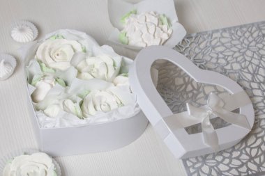 Hediye kutusunda ev yapımı marşmelov. Zephyr gülleri. Kalp şeklinde bir kutu. Fiyonka bağlanmış bir kurdeleyle bağlanmış. Şekerleme gülleri. Kalp şeklinde kutu.