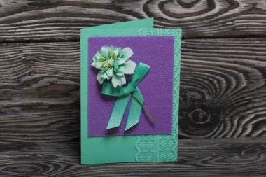 El yapımı kartpostallar. Çiçek ve kurdele şeklinde dekoratif elementlerle. Çam ağacının arka planında.