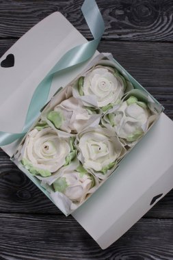 Hediye kutusunda ev yapımı marşmelov. Zephyr gülleri. Şekerleme gülleri. Siyah çam tahtalarında. Yakın çekim..