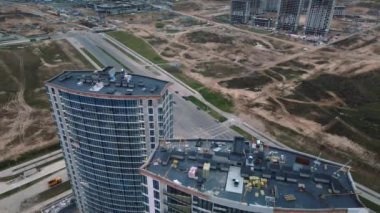 Modern çok katlı binaların yapımı. Yeni bir şehir bloğu inşaatı. İnşaat halindeki binalar ve kule vinçleri. Bulutlu havada hava fotoğrafçılığı.