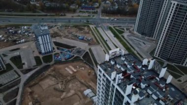 Modern çok katlı binaların yapımı. Yeni bir şehir bloğu inşaatı. İnşaat halindeki binalar ve kule vinçleri. Bulutlu havada hava fotoğrafçılığı.