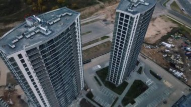 Modern çok katlı binaların yapımı. Yeni bir şehir bloğu inşaatı. İnşaat halindeki binalar ve kule vinçleri. Bulutlu havada hava fotoğrafçılığı.