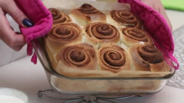 Woman Demonstrates Cooked Cinnabons Puts Them Table Begins Cover Them — Stock Video