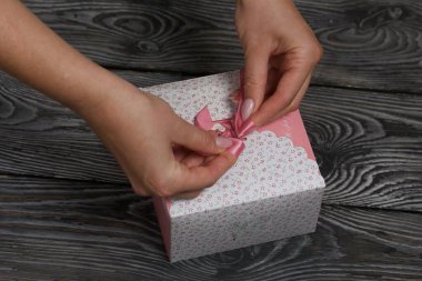 Kadın fiyonkta kurdele bağlıyor. Hediye kutusunda ev yapımı marşmelov. Zephyr gülleri. Şekerleme gülleri. Siyah çam tahtalarında. Yakın çekim..