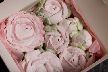 Hediye kutusunda ev yapımı marşmelov. Zephyr gülleri. Şekerleme gülleri. Siyah çam tahtalarında. Yakın çekim..