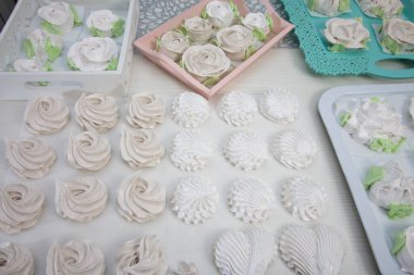 Ev yapımı marşmelov. Zephyr gülleri. Şekerleme gülleri. Masa yüzeyine yayılmış..