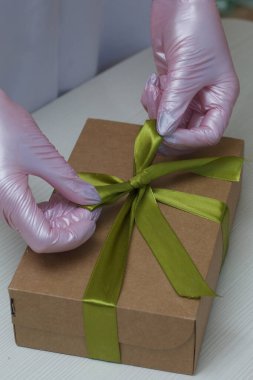 Bir kadın el yapımı marşmelovları el işi kutularda toplayıp kurdeleyle bağlıyor. Gül şeklinde Zephyr. Yakın çekim..