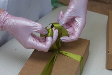 Bir kadın el yapımı marşmelovları el işi kutularda toplayıp kurdeleyle bağlıyor. Gül şeklinde Zephyr. Yakın çekim..