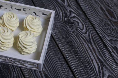 Limon ve zencefilli ev yapımı sarı marşmelov. Siyah çam ağacından bir arka planda.