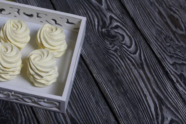 Limon ve zencefilli ev yapımı sarı marşmelov. Siyah çam ağacından bir arka planda.