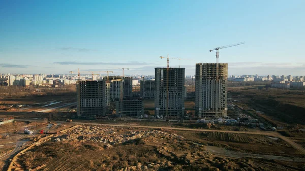 建設現場だ 近代的な複数階建ての建物の建設 建設クレーンの作業が見える 青空を背景に 空中写真 — ストック写真
