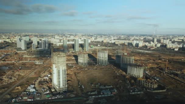 建筑工地建造现代化的多层楼房 建筑用起重机的工作是看得见的 在蓝天的背景下 空中摄影 — 图库视频影像