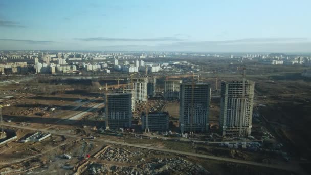 建筑工地建造现代化的多层楼房 建筑用起重机的工作是看得见的 在蓝天的背景下 空中摄影 — 图库视频影像