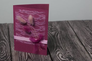 Tebrik kartları hazırlıyorum. Kağıt kurşunlar, kurdeleler ve lagurular. Siyah çam ağaçlarının üzerinde yatıyorlar..