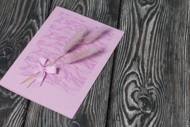 Tebrik kartları hazırlıyorum. Kağıt kurşunlar, kurdeleler ve lagurular. Siyah çam ağaçlarının üzerinde yatıyorlar..