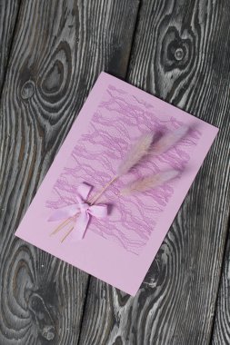 Tebrik kartları hazırlıyorum. Kağıt kurşunlar, kurdeleler ve lagurular. Siyah çam ağaçlarının üzerinde yatıyorlar..