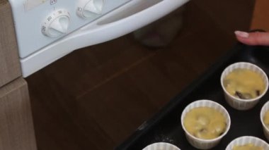 Kadın, kek için teyzesiyle birlikte fırına yemek örtüsü koyuyor. Çikolatalı ve kuru üzümlü kek hazırlıyor. Yukarıdan yakın çekim.