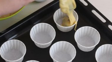 Bir kadın hamuru kek tepsisine koyar. Çikolatalı ve kuru üzümlü kek hazırlıyor. Yakın çekim..