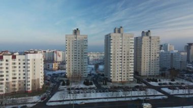 Şehir üzerinde uçuş. Modern çok katlı binalar. Kış şehri manzarası. Sisli bir sis görünür. Hava fotoğrafçılığı.