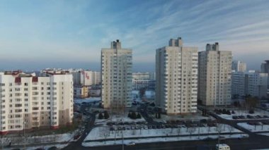 Şehir üzerinde uçuş. Modern çok katlı binalar. Kış şehri manzarası. Sisli bir sis görünür. Hava fotoğrafçılığı.