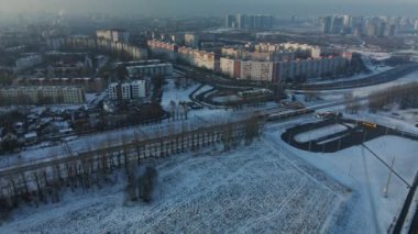 Şehir üzerinde uçuş. Kış şehri manzarası. Şehir otoyolu görünür. Sisli bir sis görünür. Hava fotoğrafçılığı.