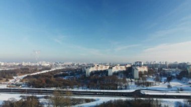 Şehir üzerinde uçuş. Kış şehri manzarası. Şehir otoyolu görünür. Sisli bir sis görünür. Hava fotoğrafçılığı.