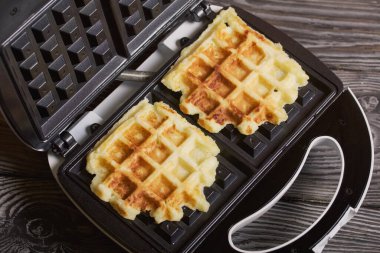 Waffle yapan waffle yapan. Siyah çam tahtalarında. Yakın çekim..