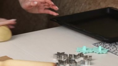 Bir kadın bisküvi yapmak için bir parça hamur karıştırıyor. Marshmallow sandviçi pişiriyorum. Malzemeler ve aletler masaya serildi. Yakın çekim..