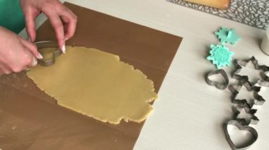 Kalp şeklinde kurabiye hamuruyla çalışan bir kadın. Marshmallow sandviçi pişiriyorum. Yakınlarda hamur için formlar var..