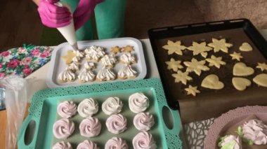 Kadın marşmelovlu sandviç hazırlıyor. Hazır tatlılar tepsilerin üzerine konur. Yakın çekim...