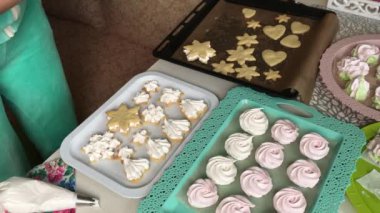 Kadın marşmelovlu sandviç hazırlıyor. Hazır tatlılar tepsilerin üzerine konur. Yakın çekim.