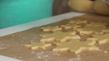 Kadın rulo hamurla çalışıyor. Hamuru bir kar tanesi şeklinde parçalara ayırır. Marshmallow sandviçi hazırlıyor. Yakın çekim.