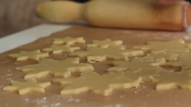 Kadın rulo hamurla çalışıyor. Hamuru bir kar tanesi şeklinde parçalara ayırır. Marshmallow sandviçi hazırlıyor. Yakın çekim..