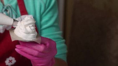 Kadın lokum külahı yapıyor. Pasta poşeti kullanıyor. Yakın çekim _