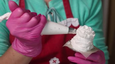 Kadın lokum külahı yapıyor. Kek poşeti kullanarak, tezgahta. Yakın çekim..