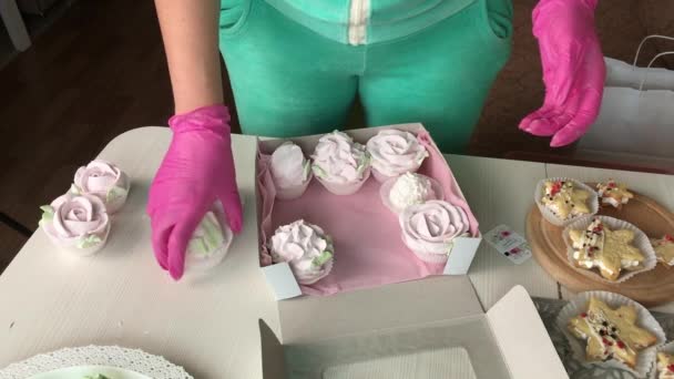 一个女人正在把棉花糖装进箱子里 各种形状和尺寸的棉花糖 棉花糖玫瑰 棉花糖铺在桌子上 — 图库视频影像