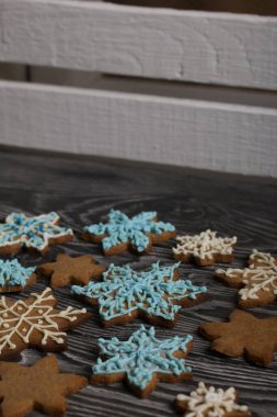 Kar tanesi şeklinde zencefilli kurabiye. Şeker jölesiyle süslenmiş. Kar tanesi şeklinde zencefilli kurabiye. Kara tahtaya uzan. Yakın çekim..