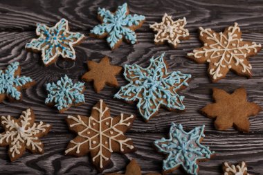 Kar tanesi şeklinde zencefilli kurabiye. Şeker jölesiyle süslenmiş. Kar tanesi şeklinde zencefilli kurabiye. Kara tahtaya uzan. Yakın çekim..