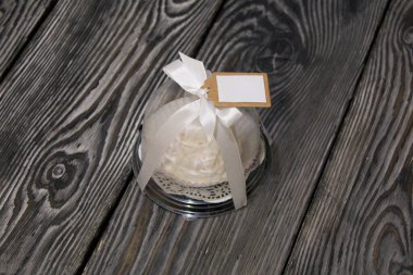 Şeffaf bir şişede lokum konileri. Fiyonka bağlanmış bir kurdeleyle bağlanmış. Çam ağacında.