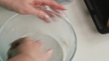 Bir kadın zencefilli ekmeği elleriyle karıştırıyor. Kar taneleri ve yıldız şeklinde zencefilli ekmek pişirmek. Yakın plan..