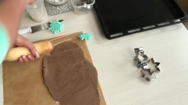 Bir kadın mercimeği fırına veriyor. Merdaneye ve hamura un serpiyor. Kar taneleri ve yıldız şeklinde zencefilli ekmek pişirmek. Genel plan.