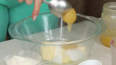 Bir kadın zencefilli ekmeğe bal ekler. Masadaki hamurun malzemeleri. Kar taneleri ve yıldız şeklinde zencefilli ekmek pişirmek. Krip planıyla çekildi..