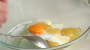 Bir kadın zencefilli kurabiye hamuruna yumurta sarısı ekler. Konteynırdaki hamur için gerekli malzemeler. Kar taneleri ve yıldız şeklinde zencefilli ekmek pişirmek. Yakın çekim..