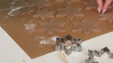 Bir kadın rulo hamurdan zencefilli ekmek keser. Bıçakla fazla hamur çıkarıyor. Yakın plan..