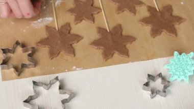 Çubukta zencefilli çörek. Kar taneleri ve yıldızlar şeklinde zencefilli ekmek. Yakınlarda zencefilli ekmek kalıpları var. Yakın plan..