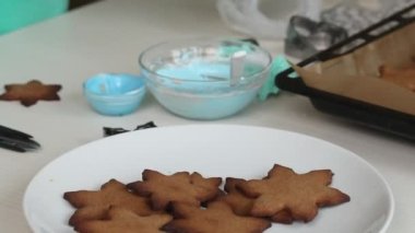 Kadın zencefilli ekmeği süslemek için krema yapıyor. Yakın plan..