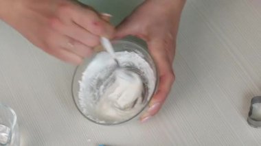 Kadın zencefilli ekmeği süslemek için krema yapıyor. Su ve krema karışımı. Yakın plan..